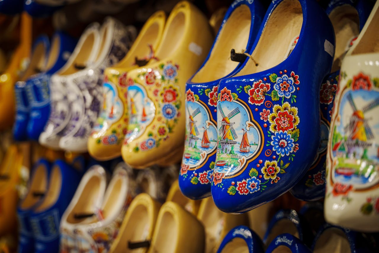 Vibrant display of traditional Dutch wooden shoes, decorated with intricate windmill designs.